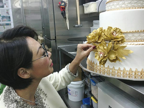 Bonnae Gokson decorates a wedding cake at Ms B's Cakery. (Photo/Provided to China Daily)