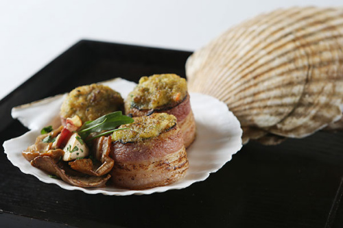 A spread of dishes at China Grill include Canadian scallops wrapped in pancetta with roasted wild mushrooms, wax gourd soup and a variety of seafood. (Photo provided to China Daily)