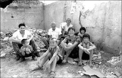 A family photo taken in front of their destroyed house in Zhechuan, Henan Province
