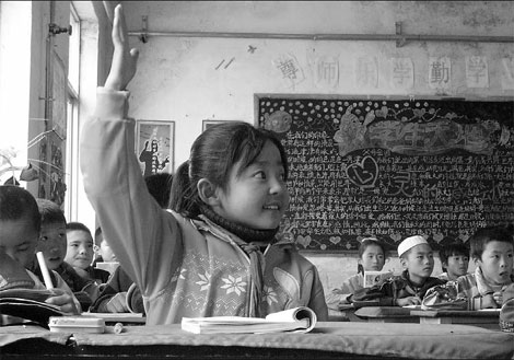 A third grader raises her hand to answer her teacher's question at Wangji School in Dongxiang county, Gansu province. Photos by Zhang Yue / China Daily