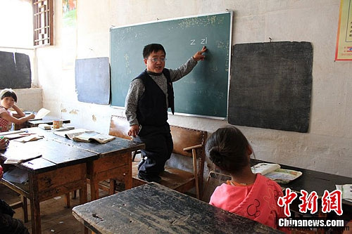 Guo Xing, standing on the tall stool, is teaching his students. 
