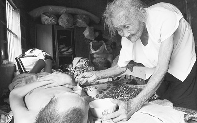 A 97-year-old mother surnamed Zhang has been taking care of her paralyzed son for about 40 years all by herself. 