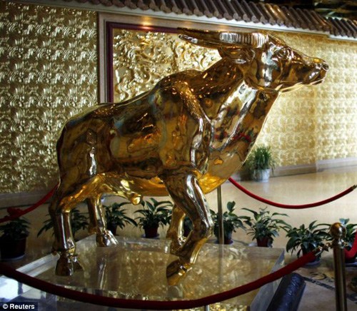 A solid gold ox costing an estimated 400 million yuan greets people on the 60th floor of the 328-meter tower.