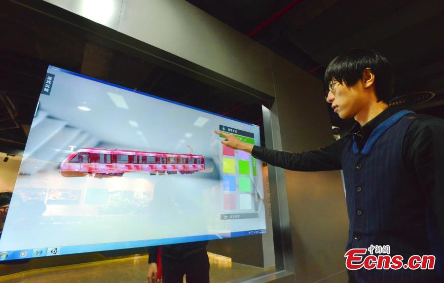 A man tries a game to design virtual subway cars at the metro museum in Shanghai on Tuesday, October 28, 2014.[Photo: China News Service/ Yuan Jing]