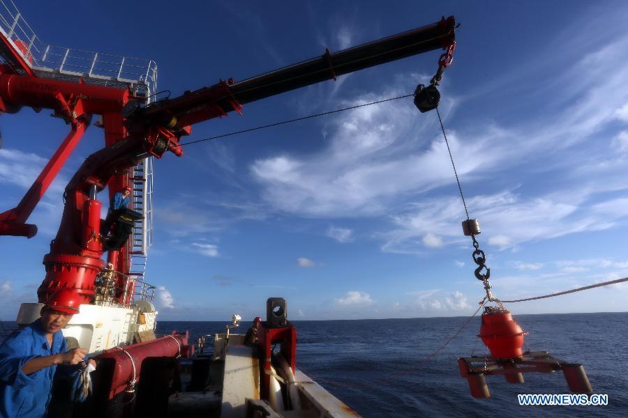 Researchers of the Kexue (Science) research vessel put down a seismometer into the ocean on the Yap Seamount sea area in the West Pacific, Jan 18, 2015. Kexue has put seven seismometers in the bottom of the ocean around this area. (Xinhua/Meng Jing)