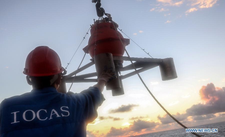 A researcher of the Kexue (Science) research vessel puts down a seismometer into the ocean on the Yap Seamount sea area in the West Pacific, Jan 19, 2015. Kexue has put seven seismometers in the bottom of the ocean around this area. (Xinhua/Meng Jing)
