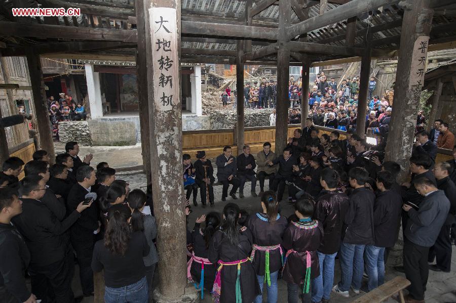 Chinese Premier Li Keqiang, also a member of the Standing Committee of the Political Bureau of the Communist Party of China (CPC) Central Committee, communicates with college and university students who have returned for Spring Festival at Pudong Village of Liping County, Qiandongnan Miao and Dong Autonomous Perfecture of southwest China\'s Guizhou Province, Feb. 13, 2015. Li made a tour in Qiandongnan Miao and Dong Autonomous Perfecture and Guiyang in Guizhou on Feb. 13 - 15, and extended festival greetings to locals and people of all ethnic groups ahead of the Spring Festival, which falls on Feb. 19. (Photo: Xinhua/Huang Jingwen)