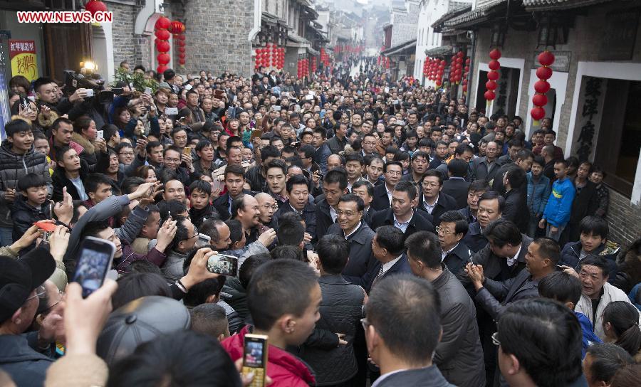 Chinese Premier Li Keqiang, also a member of the Standing Committee of the Political Bureau of the Communist Party of China (CPC) Central Committee, visits local residents on Qiaojie Street of Liping County, Qiandongnan Miao and Dong Autonomous Perfecture of southwest China\'s Guizhou Province, Feb. 13, 2015. Li made a tour in Qiandongnan Miao and Dong Autonomous Perfecture and Guiyang in Guizhou on Feb. 13 - 15, and extended festival greetings to locals and people of all ethnic groups ahead of the Spring Festival, which falls on Feb. 19. (Photo: Xinhua/Huang Jingwen)