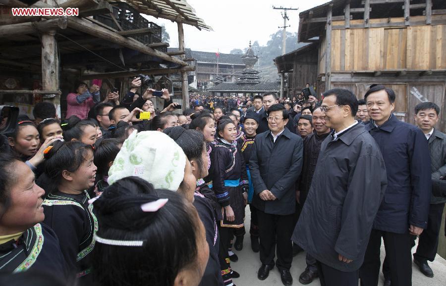 Chinese Premier Li Keqiang, also a member of the Standing Committee of the Political Bureau of the Communist Party of China (CPC) Central Committee, listens to local villagers singing a farewell song at Pudong Village of Liping County, Qiandongnan Miao and Dong Autonomous Perfecture of southwest China\'s Guizhou Province, Feb. 13, 2015. Li made a tour in Qiandongnan Miao and Dong Autonomous Perfecture and Guiyang in Guizhou on Feb. 13 - 15, and extended festival greetings to locals and people of all ethnic groups ahead of the Spring Festival, which falls on Feb. 19. (Photo: Xinhua/Huang Jingwen)