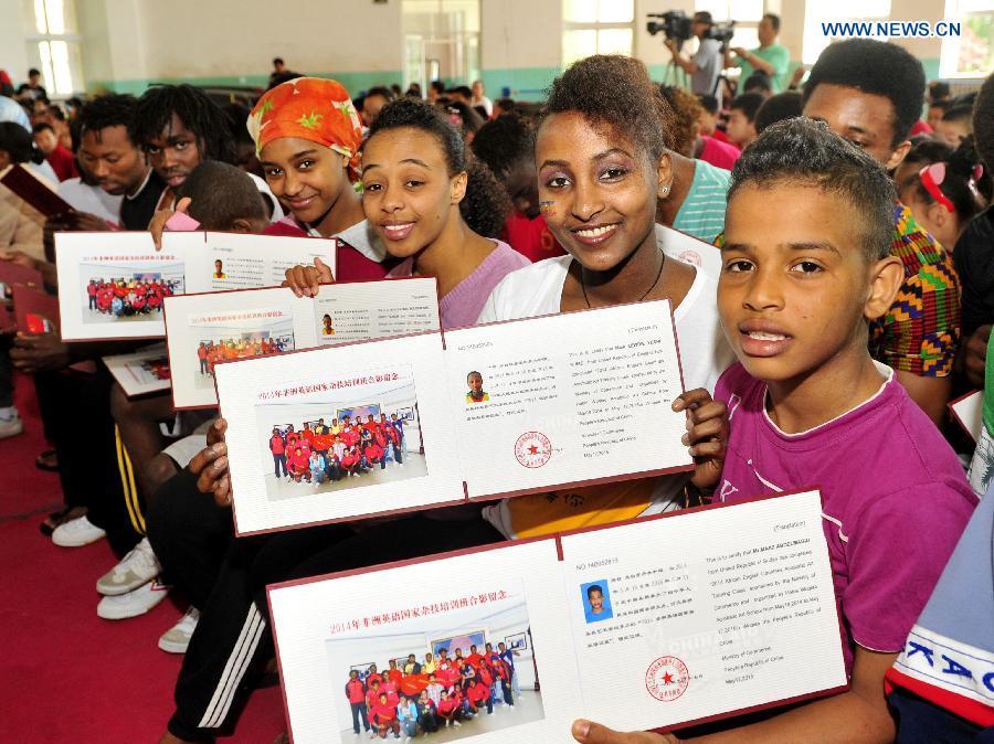 African students show their diplomas on the commencement of their acrobatic course in Cangzhou, north China\'s Hebei Province, May 13, 2015. Twenty-six students from English-speaking African countries took the one-year acrobatic course in Wuqiao International Acrobatic Art School and acquired skills of about 20 acrobatic shows. Wuqiao county, also known as \