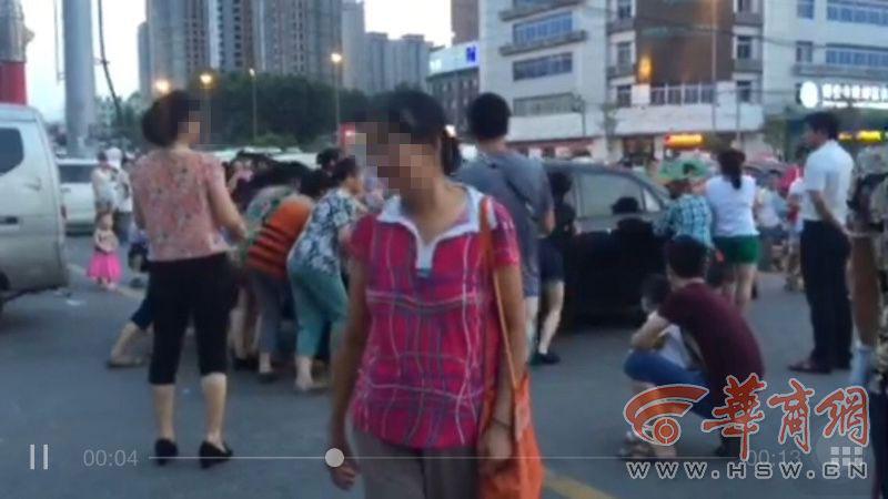 More than ten middle-aged women are seen pushing a car parked on the road in Xi\'an, in northwestern China, on 22nd July, 2015. Three cars were reportedly moved successively. The women turned out to be enthusiasts of the evening line dance, known in China as \