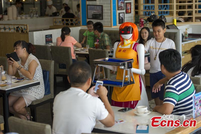 A robot waitress about 1.5 meters works for a Hong Kong style tea restaurant in Haikou, Hainan Province, in August 3,2015.Her Life is about 7 to 10 years, after an electric charge she can keep working 12 hours. She can speak, serve food, sing and greet. (CNS photo/Luo Yunfei)