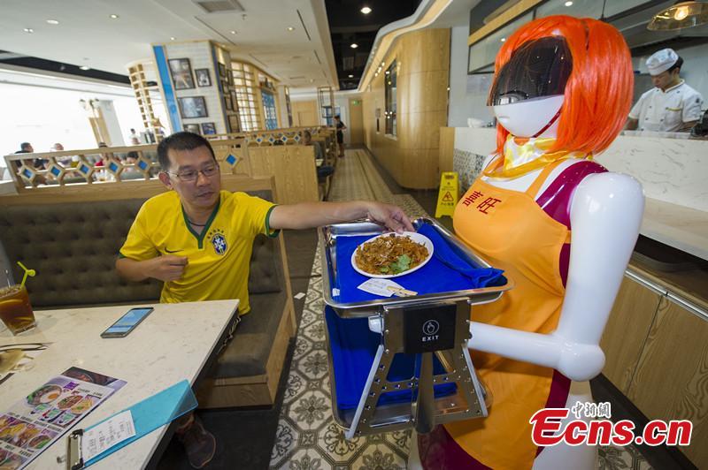 A robot waitress about 1.5 meters works for a Hong Kong style tea restaurant in Haikou, Hainan Province, in August 3,2015.Her Life is about 7 to 10 years, after an electric charge she can keep working 12 hours. She can speak, serve food, sing and greet. (CNS photo/Luo Yunfei)