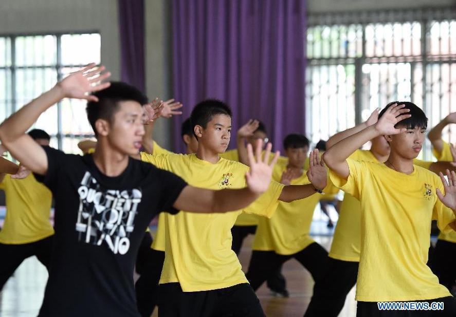 Overseas Chinese youth learn to perform Tai Chi during the \