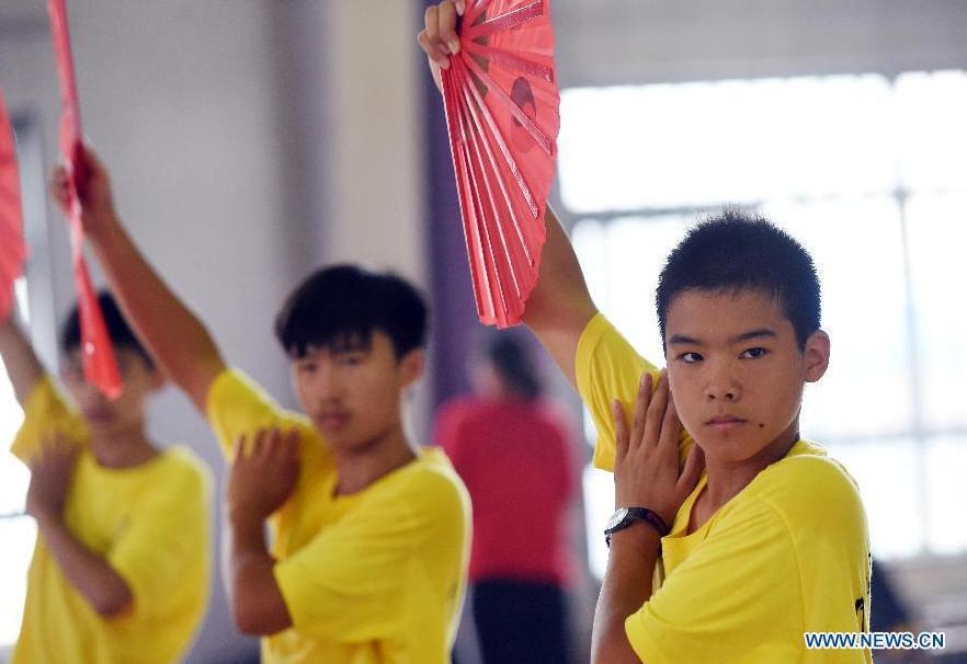Overseas Chinese youth learn to perform Kung Fu Fan during the \