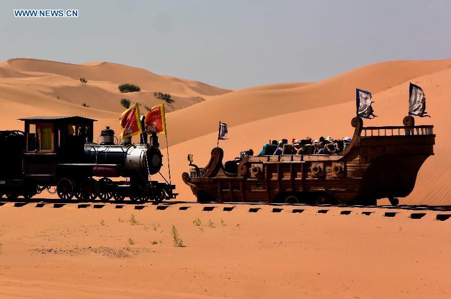 Photo taken on Aug. 6, 2015 shows people visiting Xiangshawan Desert in Ordos, north China\'s Inner Mongolia Autonomous Region. Desert Tourism in northwest China attracts a large number of tourists from home and abroad.  (Photo: Xinhua/Wang Song)