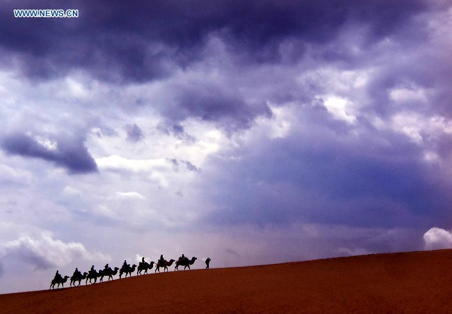 Photo taken on Sept. 10, 2015 shows people riding on camels at the Shahu Lake scenic spot in northwest China\'s Ningxia Hui Autonomous Region. Desert Tourism in northwest China attracts a large number of tourists from home and abroad.  (Photo: Xinhua/Wang Song)