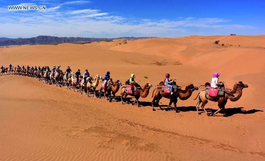 Photo taken on Sept. 12, 2015 shows people visiting the Shapotou scenic spot in northwest China\'s Ningxia Hui Autonomous Region. Desert Tourism in northwest China attracts a large number of tourists from home and abroad.  (Photo: Xinhua/Wang Song)