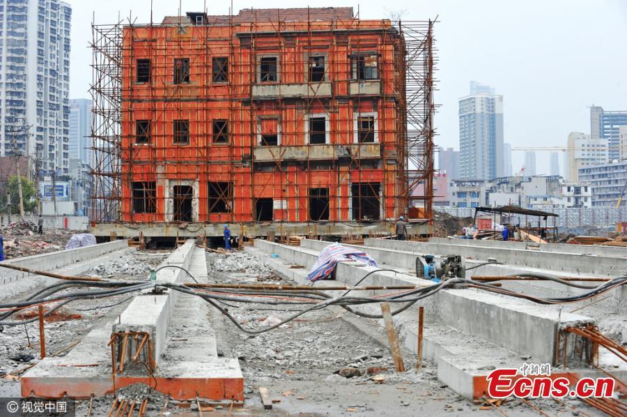 A historic building listed as a cultural relic under government protection is moved as a whole unit in Wuhan City, the capital of Central China’s Hubei Province, March 9, 2016. The three-storeyed, 100-year-old building was first raised 1.4 meters off the ground and then supported by scaffolding in order to move it for 90 meters on six reinforced-concrete tracks. The site is being cleared for a commercial development, local media reported. (Photo/CFP)