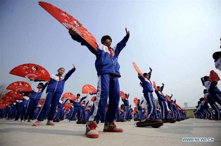 Pupils of Foyelai Primary School exercise with Taiji fans in Xinglong County of Chengde City, north China\'s Hebei Province, March 16, 2016. Students in Xinglong County learn traditional Chinese martial art, diabolo exercising and Hulusi performance during their spare time. (Photo: Xinhua/Wang Liqun)