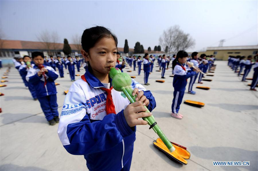 Pupils of Foyelai Primary School perform Hulusi, a gourd-shaped traditional wind instrument, in Xinglong County of Chengde City, north China\'s Hebei Province, March 16, 2016. Students in Xinglong County learn traditional Chinese martial art, diabolo exercising and Hulusi performance during their spare time. (Photo: Xinhua/Wang Liqun)