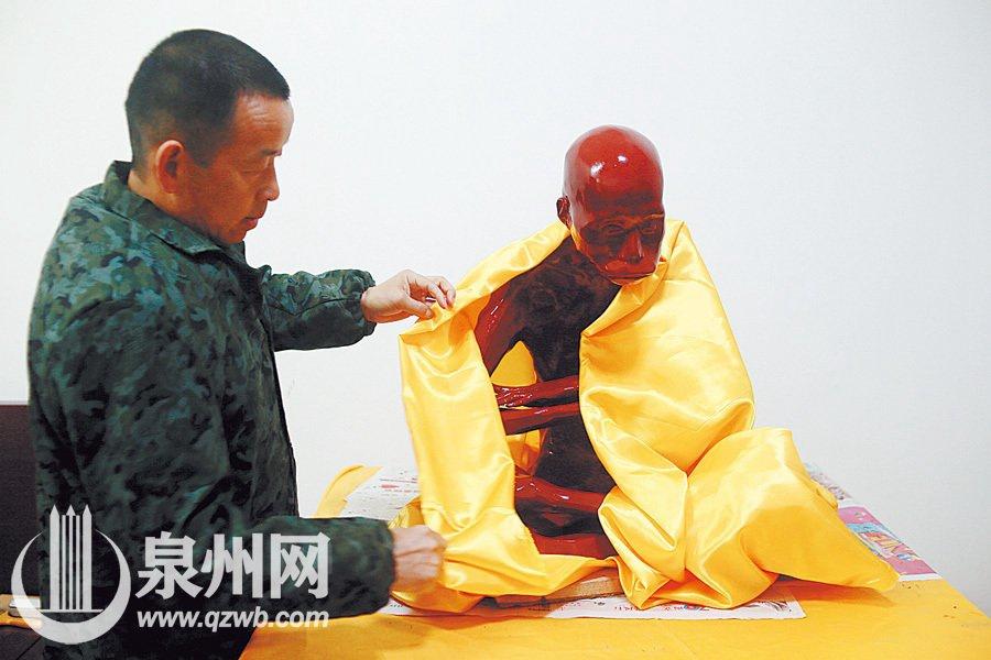 A monk in a temple in Quanzhou, southeast China\'s Fujian province, died three and a half years ago but his body did not decompose at all and was made into a gold Buddha statue. Since Jan. 10, 2016, the monk\'s body had gone through a series of treatment including sterilizing and painting. After three months, workers picked March 16 for the last process — gilding. (Photo/Qzwb.com)