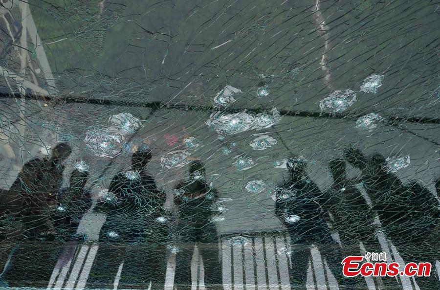 Visitor strike the glass-bottomed bridge with hammers for a safety test at Zhangjiajie Grand Canyon on June 25, 2016 in Zhangjiajie, Hunan Province of China. The bridge is 430 meters long, six meters wide and 300 meters above the valley. (Photo: China News Service/ Yang Huafeng)