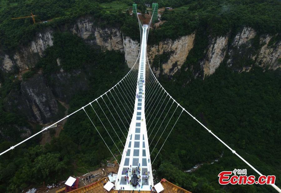 A SUV travels on a glass bridge during a load testing at the Grand Canyon of Zhangjiajie, central China\'s Hunan Province, June 25, 2016. The bridge is 430 meters long, six meters wide and 300 meters above the valley. (Photo: China News Service/ Yang Huafeng)