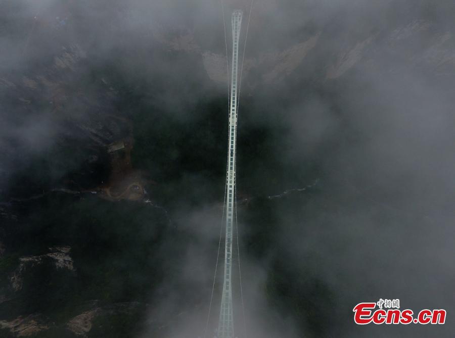 A SUV travels on a glass bridge during a load testing at the Grand Canyon of Zhangjiajie, central China\'s Hunan Province, June 25, 2016. The bridge is 430 meters long, six meters wide and 300 meters above the valley. (Photo: China News Service/ Yang Huafeng)