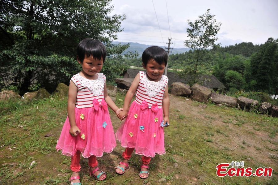 Twin sisters pose for a photo in Qingyan Village, Jiangjin District, Southwest China’s Chongqing Municipality, July 5, 2016. The village of 367 households has 39 pairs of twins, with the oldest 89 years old. (Photo: China News Service/Chen Chao)