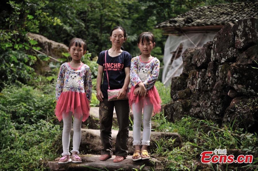 A mother and her twin daughters pose for a photo in Qingyan Village, Jiangjin District, Southwest China’s Chongqing Municipality, July 5, 2016. The village of 367 households has 39 pairs of twins, with the oldest 89 years old. (Photo: China News Service/Chen Chao)