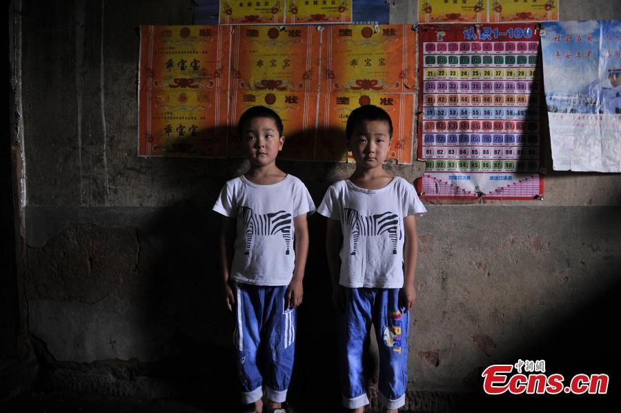 Twin brothers pose for a photo in Qingyan Village, Jiangjin District, Southwest China’s Chongqing Municipality, July 5, 2016. The village of 367 households has 39 pairs of twins, with the oldest 89 years old. (Photo: China News Service/Chen Chao)