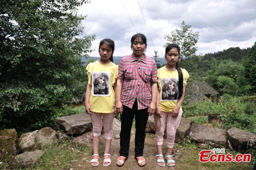 A mother and her twin daughters pose for a photo in Qingyan Village, Jiangjin District, Southwest China’s Chongqing Municipality, July 5, 2016. The village of 367 households has 39 pairs of twins, with the oldest 89 years old. (Photo: China News Service/Chen Chao)