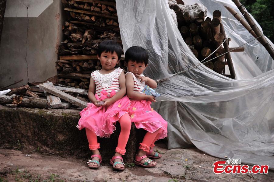Twin sisters pose for a photo in Qingyan Village, Jiangjin District, Southwest China’s Chongqing Municipality, July 5, 2016. The village of 367 households has 39 pairs of twins, with the oldest 89 years old. (Photo: China News Service/Chen Chao)