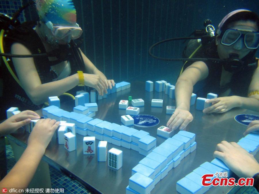 Divers don masks to play mahjong underwater at a sports park in Yubei District, Southwest China’s Chongqing Municipality, July 17, 2016. Day after day of high temperatures in Chongqing means fans are getting inventive as they try to keep cool and continue to play one of the nation’s most popular games. (Photo/IC)