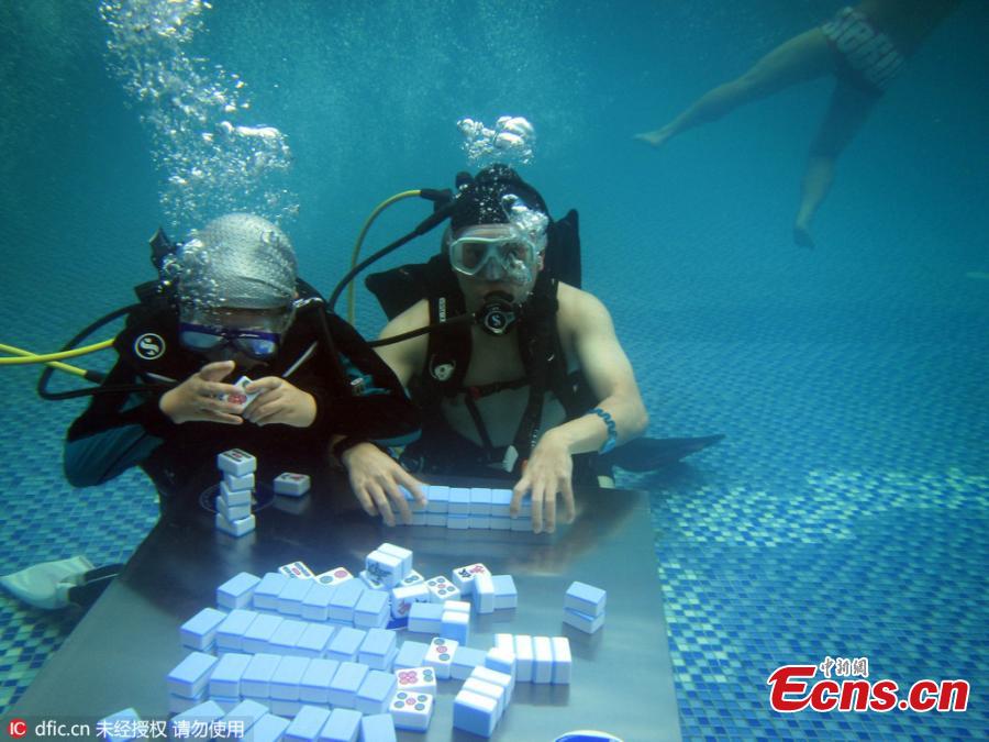 Divers don masks to play mahjong underwater at a sports park in Yubei District, Southwest China’s Chongqing Municipality, July 17, 2016. Day after day of high temperatures in Chongqing means fans are getting inventive as they try to keep cool and continue to play one of the nation’s most popular games. (Photo/IC)