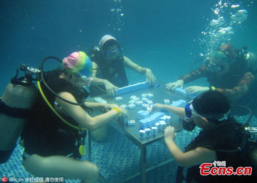 
Divers don masks to play mahjong underwater at a sports park in Yubei District, Southwest China’s Chongqing Municipality, July 17, 2016. Day after day of high temperatures in Chongqing means fans are getting inventive as they try to keep cool and continue to play one of the nation’s most popular games. (Photo/IC)