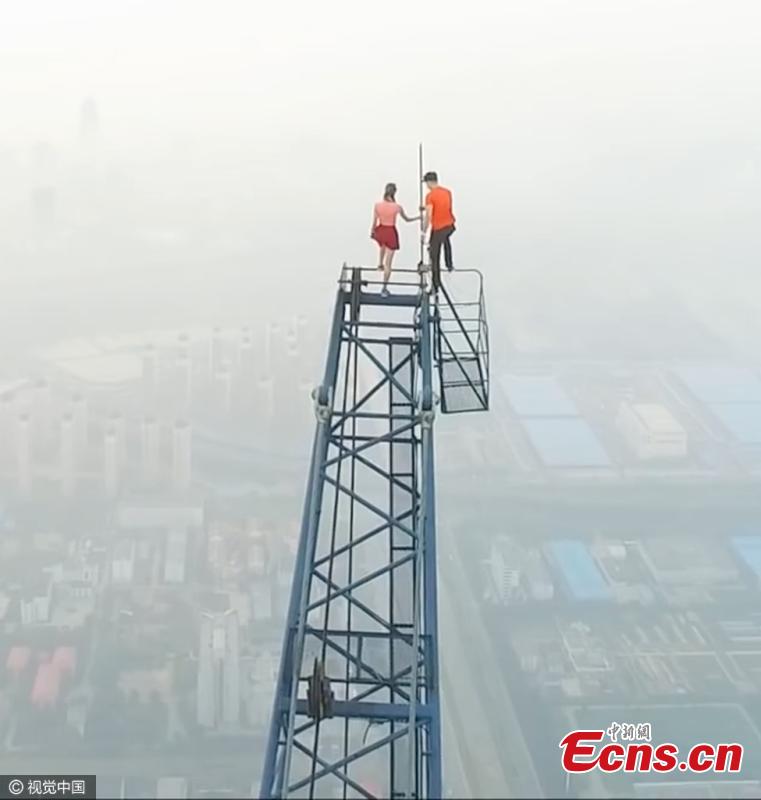 Two Russian climbers, Ivan Kuznetsov, 22, and Angela Nikolau, 23, scale the top of the 640-meter-tall Goldin Finance 117, which is under construction in North China’s Tianjin Municipality, Aug. 23, 2016. The Russian couple started their climb at 3am and used both cameras and a drone to record the process. The skyscraper is expected to be the tallest building in China after construction is complete. (Photo/CFP)