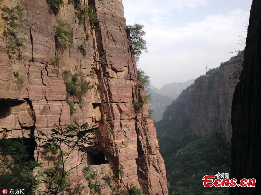 Guoliang village in Huixian County, Henan Province perches on a mountaintop 1,700 meters above sea level and is besieged by cliffs on three sides. In 1972, to find a safe way in and out of the village, local people chiseled through the stone cliffs and created a 5-meter-high and 4-meter-wide passage, using their hands and bamboo baskets to remove the stones. The 1,300-meter-long passage took the villagers five years to complete. Before the passage, stairs chiseled out along the almost vertical cliff, nicknamed \