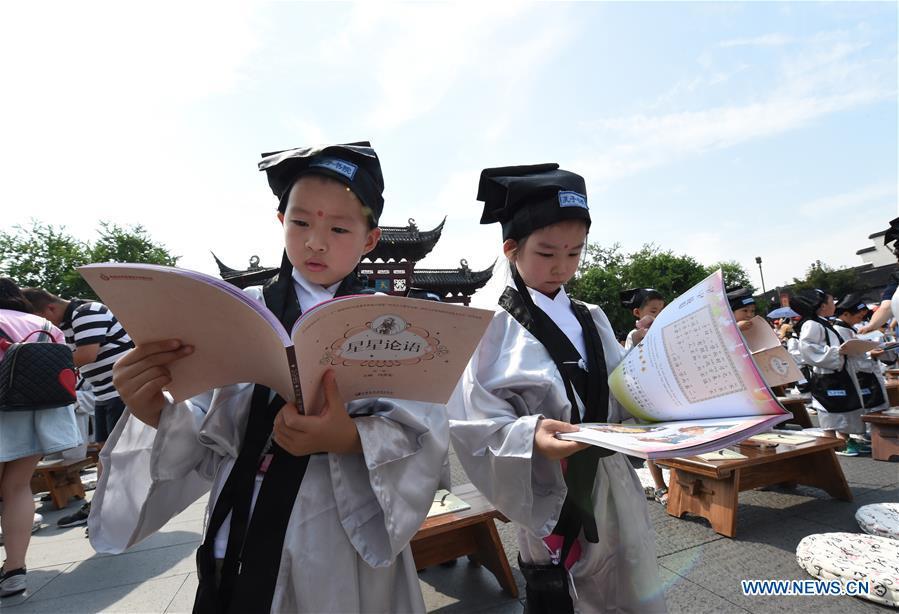 Children read the Analects of Confucius at the first writing ceremony in Nanjing, capital of east China\'s Jiangsu Province, Aug. 31, 2016. A total of 168 children attended the ceremony, a traditional education activity for children to start their school life in China, at the Confucius Temple in Nanjing on Wednesday. (Photo/Xinhua)