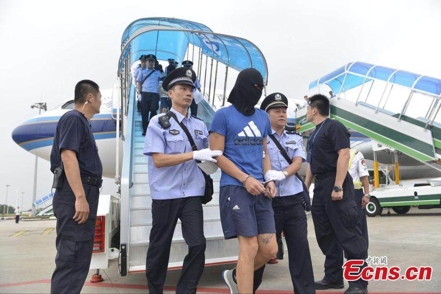 A telecom fraud suspect is escorted by police as he disembarks from a charted plane at Baiyun International Airport in Guangzhou City, capital of South China’s Guangdong Province, Sept. 2, 2016. Armenian police deported 129 Chinese telecom fraud suspects, including 78 from Taiwan, to the Chinese mainland. Investigation found that the syndicate based in Armenia had been falsely representing themselves as law enforcement officers to extort money from people on the Chinese mainland through telephone calls. They were found to have cheated people in about 50 cases worth more than 7 million yuan ($1.2 million). (Photo: China News Service/Qian Wenpan)