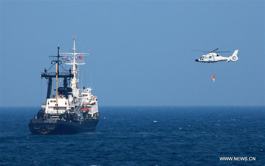 Chinese navy\'s helicopter sends a rescuer to the drowning crew of a merchant ship during a China-Russia naval joint drill at sea off south China\'s Guangdong Province, Sept. 16, 2016. Chinese and Russian fleets conducted joint operation exercise off Guangdong Province in the South China Sea during the \
