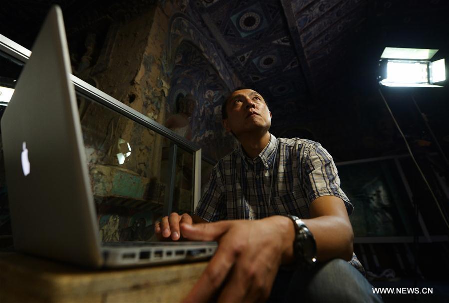 Chen Haitao, a member of the designing team with the Dunhuang Academy, works at Cave No. 254 in Mogao Grottoes, Dunhuang, northwest China\'s Gansu Province, Sept. 18, 2016. Dunhuang Academy has been working on making animated shows out of ancient Dunhuang murals using modern digital media in recent years. Two films based on murals in Cave No. 254 of Mogao Grottoes have been completed. (Xinhua/Chen Bin)
