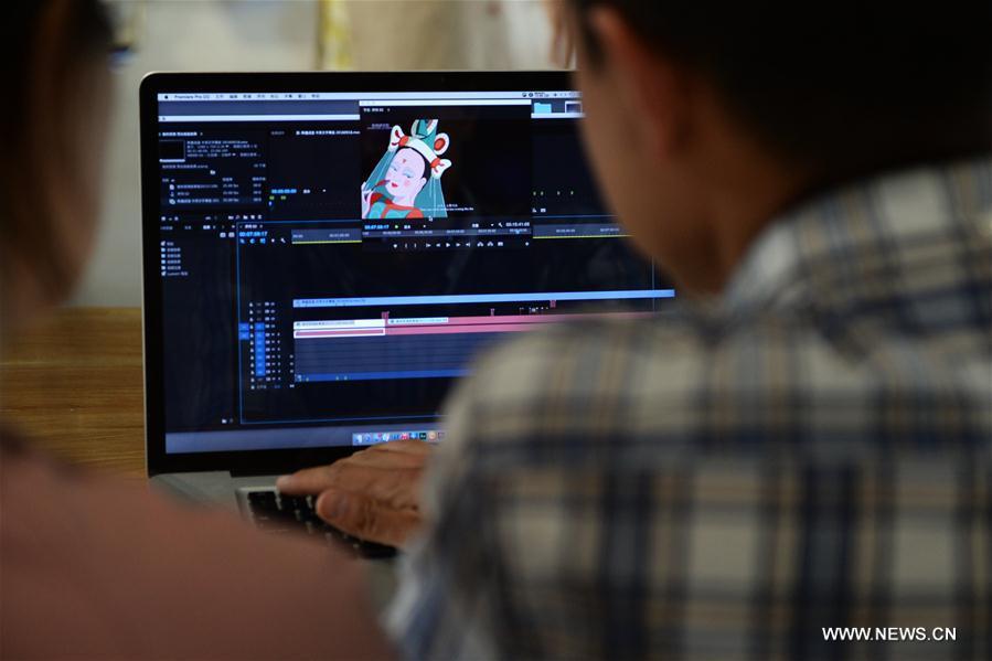 A staff member with the Dunhuang Academy edits a film in Dunhuang, northwest China\'s Gansu Province, Sept. 18, 2016. Dunhuang Academy has been working on making animated shows out of ancient Dunhuang murals using modern digital media in recent years. Two films based on murals in Cave No. 254 of Mogao Grottoes have been completed. (Photo/Xinhua)