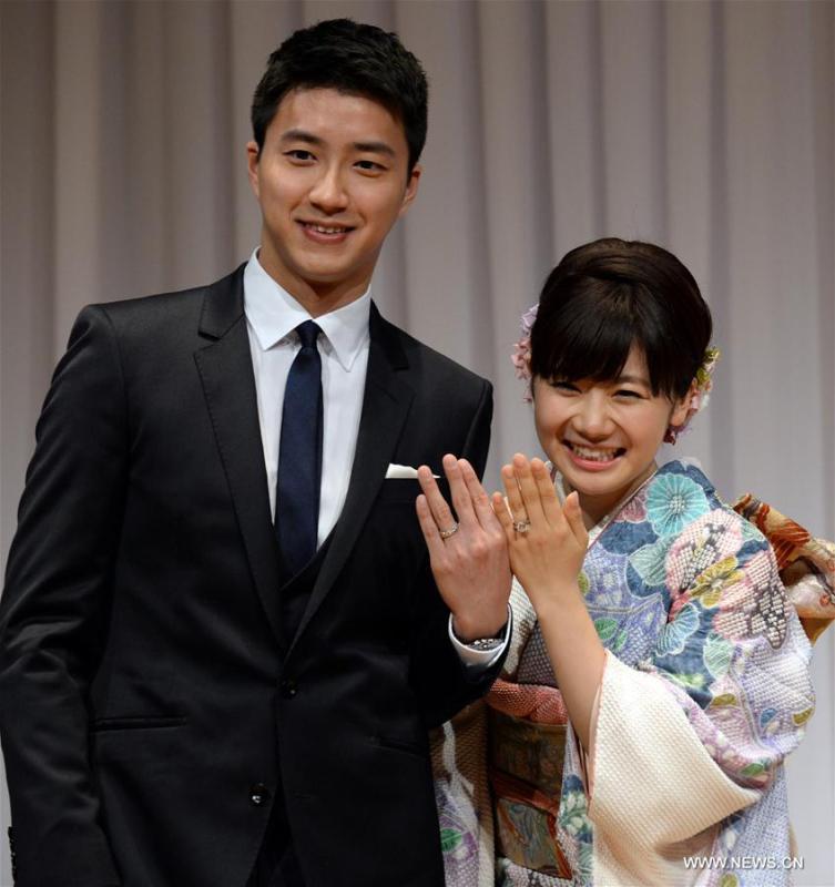 Japanese table tennis player Ai Fukuhara (R) and table tennis player Chiang Hung-Chieh of Chinese Taipei show off their marriage rings while posing for photographers during a press conference to announce their marriage in Tokyo, Japan, Sept. 21, 2016. (Photo/Xinhua)