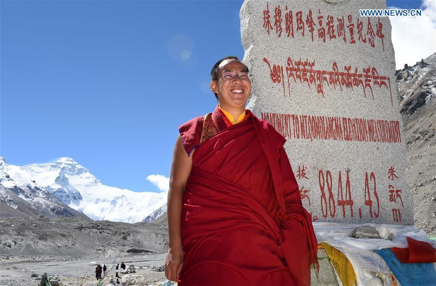 
The 11th Panchen Lama Bainqen Erdini Qoigyijabu stands at an altitude sign of Mount Qomolangma in southwest China\'s Tibet Autonomous Region, Sept. 22, 2016. The 11th Panchen Lama Bainqen Erdini Qoigyijabu visited Mount Qomolangma for the first time on Thursday. (Photo/Xinhua)