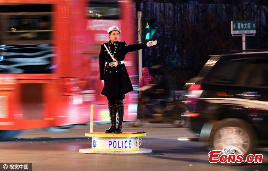Female traffic police officers in their new uniform featuring trench coat and over-the-knee boots work on a street in Shenyang, Northeast China’s Liaoning province on Monday evening, November 14, 2016. (Photo/CFP)