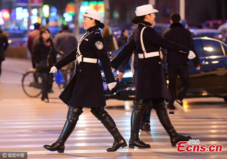 Female traffic police officers in their new uniform featuring trench coat and over-the-knee boots work on a street in Shenyang, Northeast China’s Liaoning province on Monday evening, November 14, 2016. (Photo/CFP)