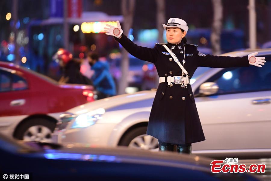 Female traffic police officers in their new uniform featuring trench coat and over-the-knee boots work on a street in Shenyang, Northeast China’s Liaoning province on Monday evening, November 14, 2016. (Photo/CFP)