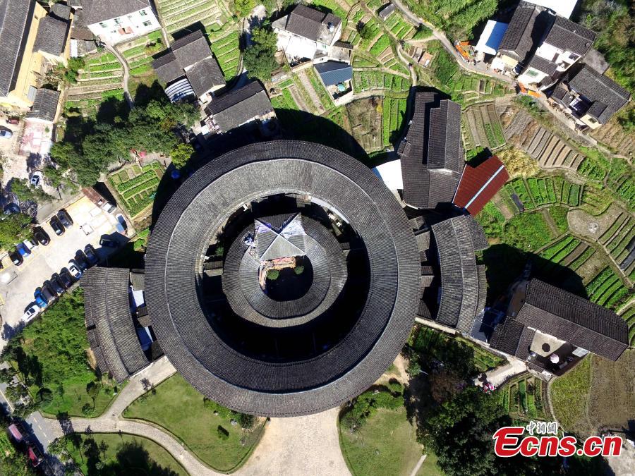 An aerial view of the Tulou in Yongding county, Southeast China\'s Fujian province, on Dec 9, 2016. Yongding has over 23,000 Tulou, a type of Chinese rural dwellings of the Hakka and Minnan people in the mountainous areas in Fujian province. Fujian Tulou is a type of Chinese rural dwellings of the Hakka and Minnan people in the mountainous areas in Fujian province. A total of 46 Fujian Tulou sites have been inscribed in 2008 by UNESCO as World Heritage Site. The biggest Tulou in Fujian is Chengqi Tulou in Yongding, which was listed as a Guinness World Record in 2010. (Photo: China News Service/ Wang Dongming)